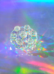 quartz crystal balls on abstract holographic background close up. Crystal prism Refracting vivid...