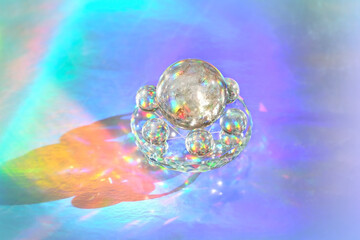 quartz crystal balls on abstract holographic background close up. Crystal prism Refracting vivid...