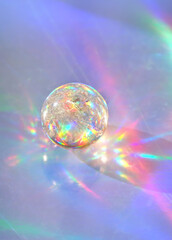 quartz crystal ball on abstract holographic background close up. Crystal ball Refracting vivid...