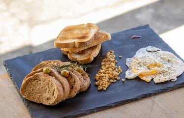 Bread slices served at table, on a dark board.