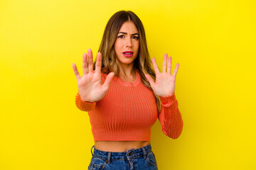 Young caucasian woman isolated on yellow background
