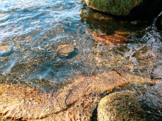 Volcanic lake shore rocks with black volcanic sand close-up in Italy near Rome. European vacation