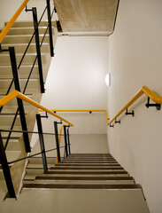service staircase with marked steps and yellow and black handrail