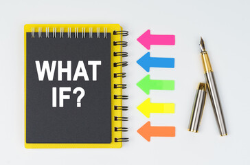 On a white background lies a pen, arrows and a notebook with the inscription - WHAT IF