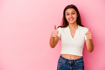 Young Indian woman isolated on pink background smiling and raising thumb up