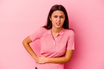 Fototapeta premium Young Indian woman isolated on pink background having a liver pain, stomach ache.