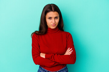 Young Indian woman isolated on blue background blows cheeks, has tired expression. Facial...
