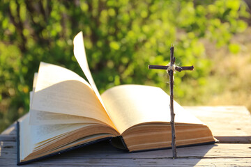 The Bible on the background of the cross and life-giving light