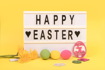 Happy Easter letters and easter eggs on yellow background