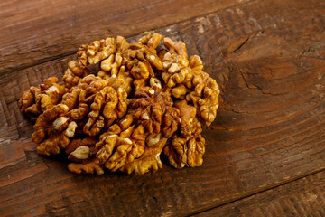 Walnuts are scattered on a dark wooden table.