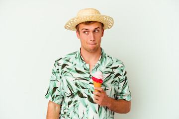 Young caucasian man wearing a summer clothes and holding a ice cream isolated on white background