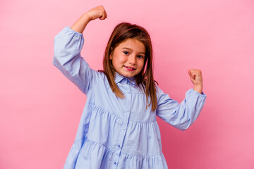 Little caucasian girl isolated on pink background  showing strength gesture with arms, symbol of...
