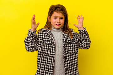 Little caucasian girl isolated on yellow background screaming with rage.