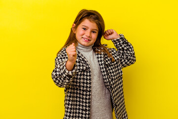 Little caucasian girl isolated on yellow background dancing and having fun.