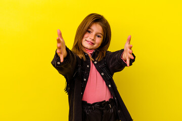 Little caucasian girl isolated on yellow background feels confident giving a hug to the camera.