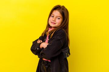 Little caucasian girl isolated on yellow background laughing and having fun.