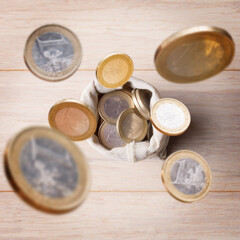 Euro coins are falling into money bag