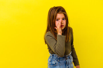 Little caucasian girl isolated on yellow background is saying a secret hot braking news and looking...