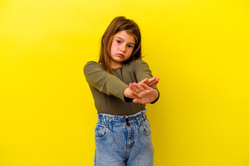 Little caucasian girl isolated on yellow background doing a denial gesture