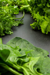 Some fresh green vegetables on a black wooden table 