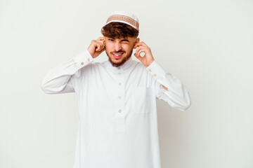 Young Arab man wearing the typical arabic costume isolated on white background covering ears with...