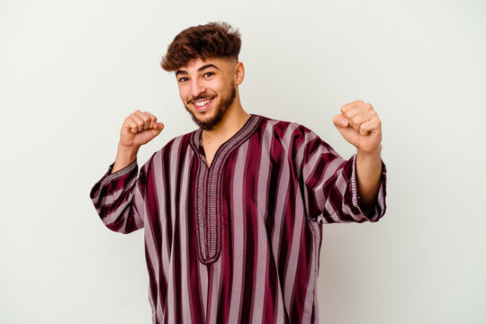 Young Moroccan man isolated on white background dancing and having fun.