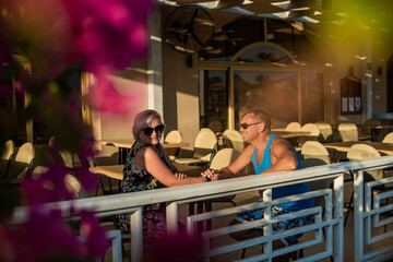 Real people marriedcouple sitting at outdoor cafe waring sunglasses.