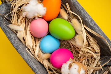 Easter Eggs in basket on yellow background