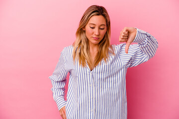 Young mixed race woman isolated on pink background showing a dislike gesture, thumbs down....