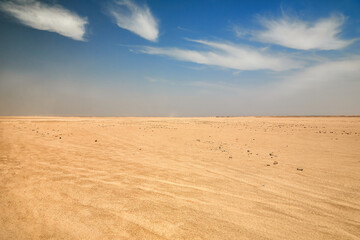 Dry desert landscape. Hot lifeless sand of desert and blue sky in summer sunny day. Flat deserf of Egypt. Travel and tourism concept. © Viktor