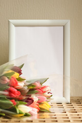 Poster with copy space in warm shades . Mockup of a wooden frame with tulips. White, minimalism. copy space. Mock up design.