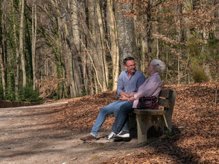 Obraz premium Senior mother and her son sitting in the park