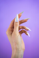 Pearlescent unicorn design manicure press-on nails isolated against a purple background