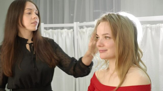a beautiful blonde in a beauty salon does hair styling