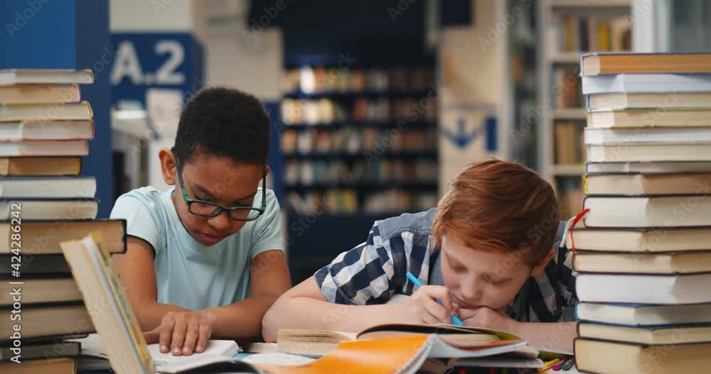 Wall mural diverse classmates falling asleep on desk with various book in library