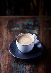 Cup of coffee on wooden background. Close up. 