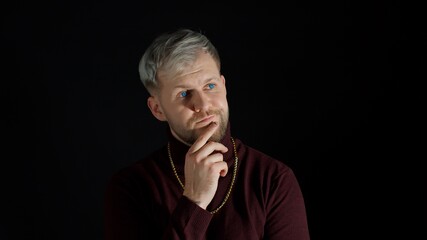Man rubbing chin and smirking while thinking over idea, imagining plan in mind, having doubts about answer, contemplating and pondering answer, pointing on camera, choose you. Black background