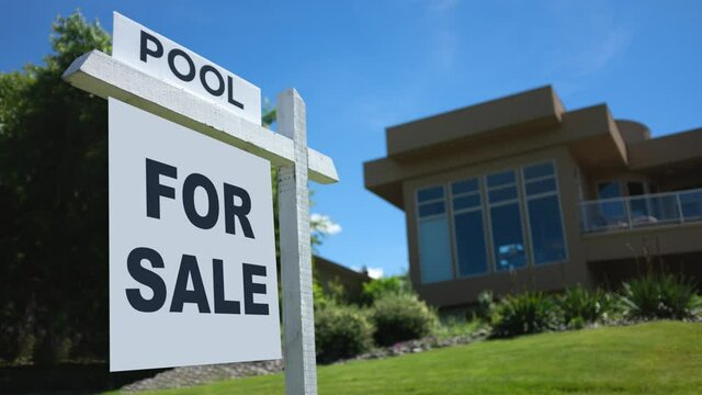 Looping Video Of A For Sale Sign Swinging In The Breeze Outside A Luxury Home With A Pool On A Bright Sunny Day