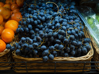 Select fruits are publicly available in the window of a self-service grocery store. Blue, purple...