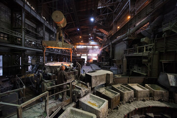 Fototapeta premium Steelworker at work near the tanks with hot metal at a steel plant