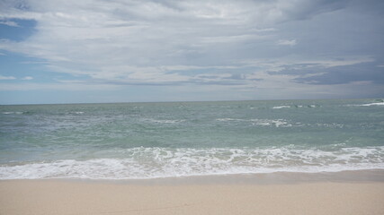 Fototapeta na wymiar Beach waves foaming on white sand