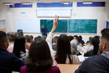 Naklejka na ściany i meble female student sitting in the class and raising hand up
