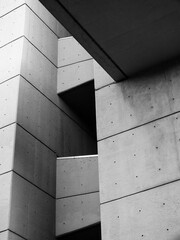 Close up detail of an angled textured grey concrete brutalist building with geometric shapes