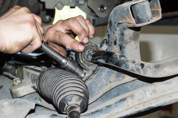 The mechanic tightens the stabilizer bushing mount