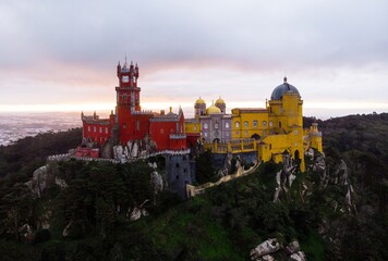 Aerial panorama of red yellow romanticist hilltop castle Palacio Nacional da Pena Palace, Sintra...