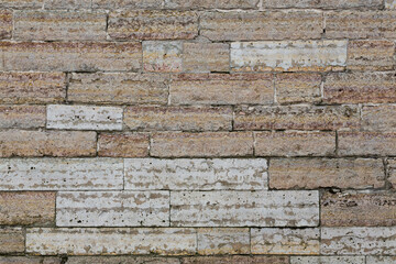 Old wall lined with decorative stone. Weathered rough surface of stones. Beautiful masonry in a classic style. Vintage texture great for background and design.