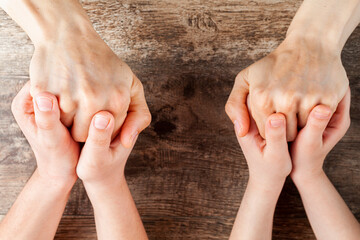 Abstract concept image showing two kids tightly holding hands of a woman. Single mom with two kids,...
