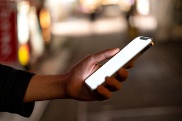 道の上でスマートフォンを開く人