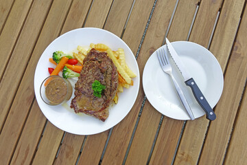 Wagyu steak served with vegetables and French fries. Top view