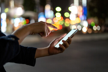 道の上でスマートフォンを開く人